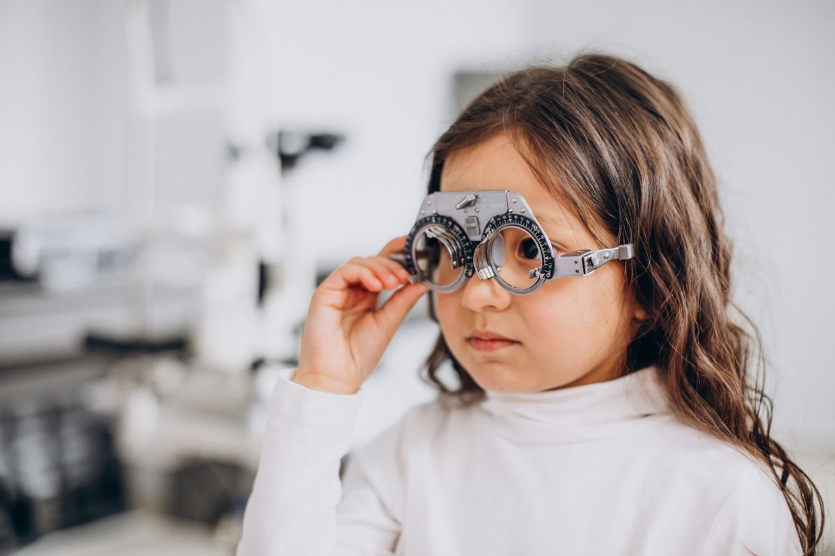 Niña durante examen de agudeza visual con armazón de prueba oftalmológico